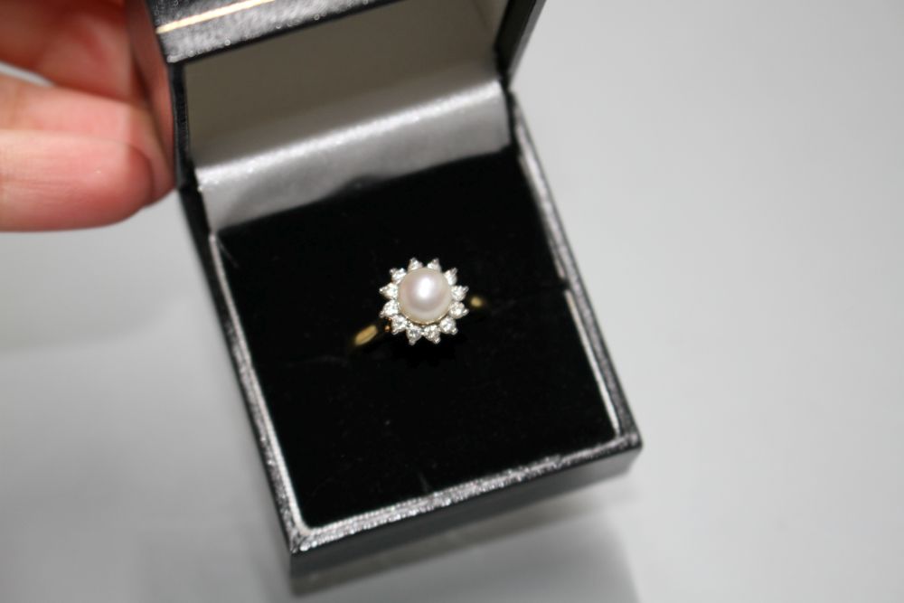 A modern 18ct gold, cultured pearl and diamond cluster set flower head ring, gross 4.4. grams.